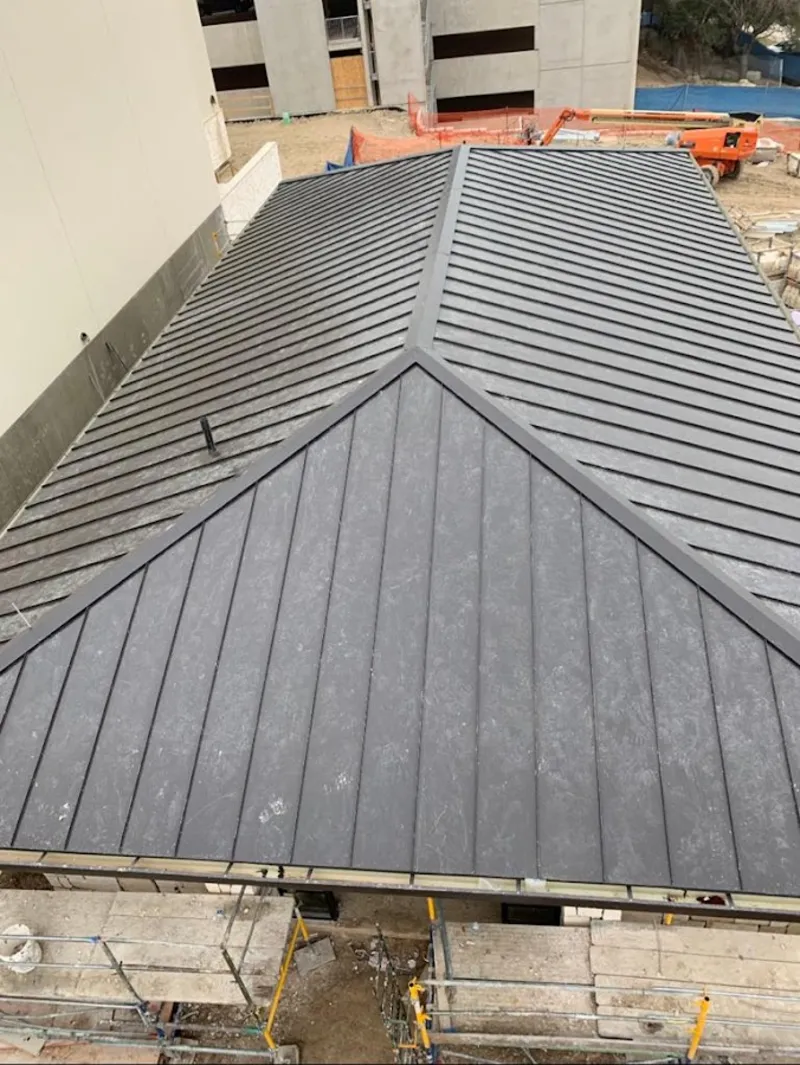 Commercial metal roof construction with crane equipment in Mountain Brook